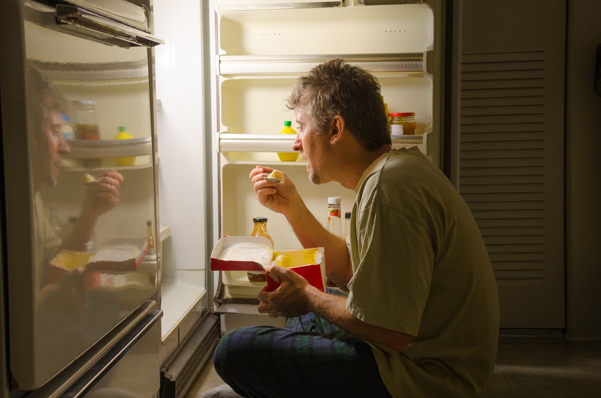 Man eating by his fridge