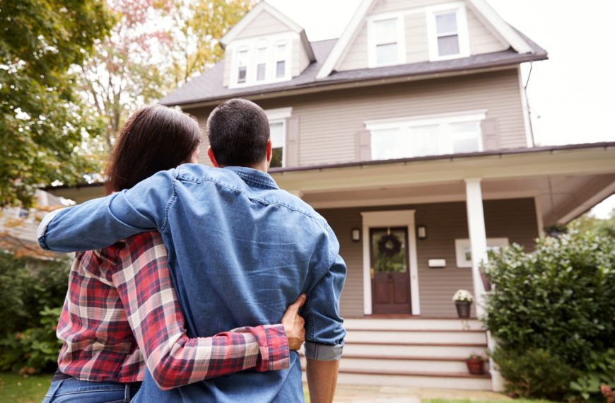 A couple looking at their new house from the outside