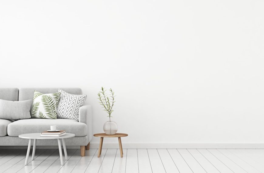 A Scandinavian minimilast living room with a gray couch, a white circular coffee table, and pillows with prints