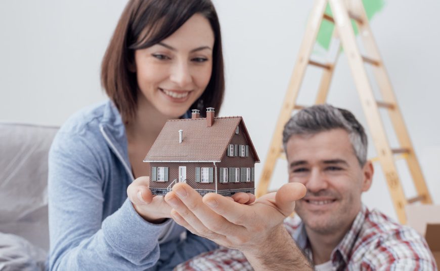 happy couple holding a house model