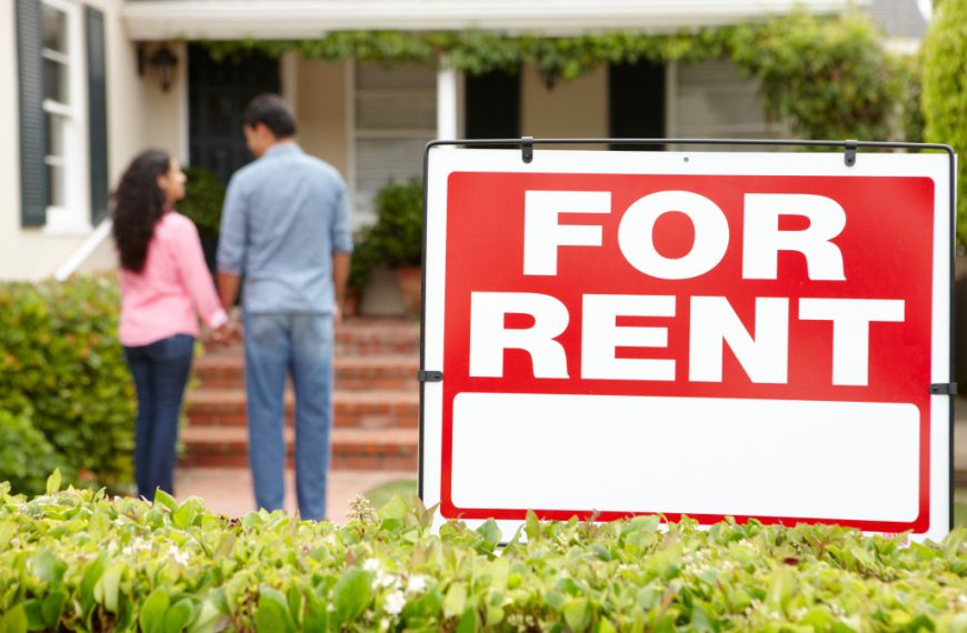 for rent sign in front of house with couple at the back
